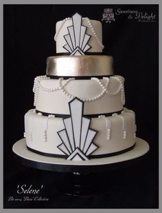 a three tiered wedding cake with white and black decorations