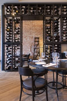 a dining room table with wine bottles on the wall