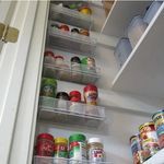 an open refrigerator filled with lots of food and drink cans next to it's door