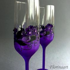 two wine glasses decorated with purple flowers and black leaves