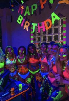 a group of young women standing next to each other in front of a birthday sign