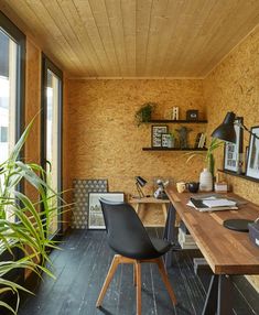 a home office with wood paneling and black chairs