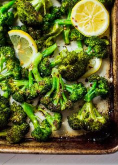 broccoli florets and lemon slices on a baking sheet