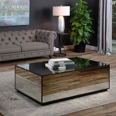 a living room with a couch, coffee table and lamp