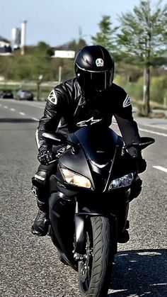 a man riding on the back of a black motorcycle