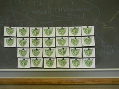 a blackboard with some green and white designs on it's side, in front of the chalk board