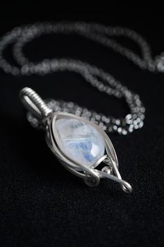 "Elegant handmade genuine tear drop cut moonstone framed in pure sterling silver. Held on an 18 inch / 45cm stainless steel chain. With a sliding sterling silver bead.  Dimensions: Pendant: 1.5cm/0.59\" wide by 4cm/1.57\" long (includes bail) 18\" / 45cm chain All materials: Moonstone  Stirling silver  Stainless steel  Platinum silver" White Sterling Silver Hand-wrapped Necklaces, Sterling Silver Hand Wrapped White Necklaces, Hand Wrapped White Sterling Silver Necklaces, Silver Moonstone Pendant Jewelry, Handmade Moonstone Jewelry In White Gold, Hand Wrapped Sterling Silver Jewelry, Handmade White Gold Moonstone Jewelry, Silver Teardrop Jewelry With Hand-wrapped Detail, Moonstone Teardrop Pendant Jewelry