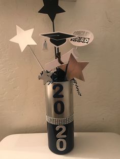 a black and silver vase filled with paper stars