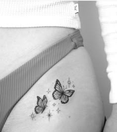 a woman's stomach with two butterflies tattoo on the side of her belly,