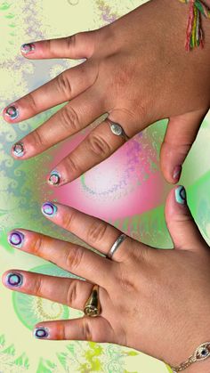 two women's hands with rings on their fingers and nail polishes in different colors