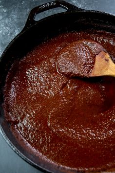 a wooden spoon stirring chocolate in a skillet