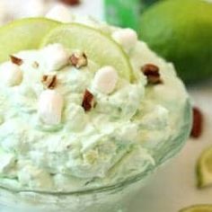 a close up of a bowl of food with limes and nuts on the side