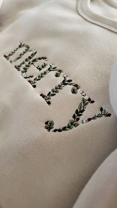 a close up of a cross stitched sweatshirt with the words, faith and holly on it