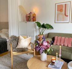 a living room filled with furniture and flowers on top of a table in front of a couch