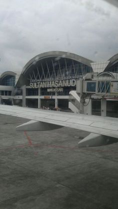 an airplane wing that is sitting on the ground in front of a building with many windows