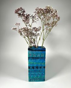 a blue vase filled with flowers on top of a table