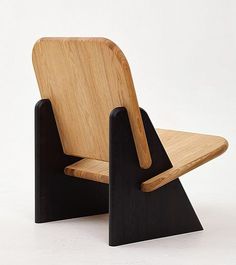 a wooden chair sitting on top of a white floor next to a black stand up