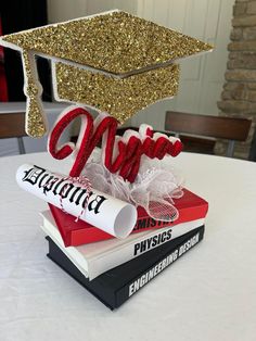 a graduation cap on top of books with the word class spelled out in red and white