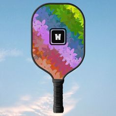 a multicolored tennis racket with the letter w on it's back