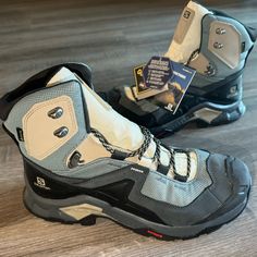 a pair of hiking boots sitting on top of a wooden floor next to each other