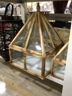 a glass and wood lantern on display in a store