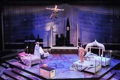 an image of a stage setting with people on the bed and in the middle of it