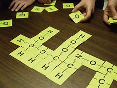 several people sitting at a table playing with letters and numbers