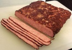 a sliced up meatloaf sitting on top of a cutting board