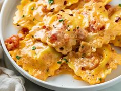 a white plate topped with pasta covered in cheese