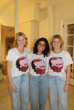 three women standing next to each other wearing t - shirts