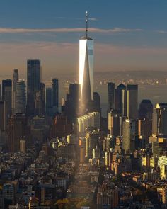 an aerial view of the city skyline with skyscrapers in the foreground and sunlight shining down on it