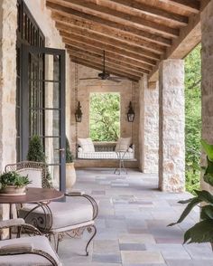 an outdoor covered porch with stone walls and flooring is shown in the foreground