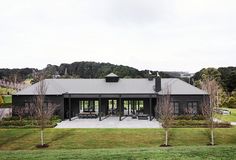 the house is surrounded by lush green trees and grass, with an outdoor dining area