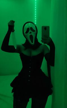 a woman wearing a mask and holding a cell phone