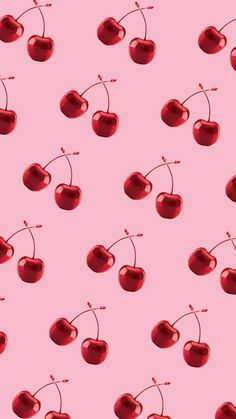 cherries on a pink background with red stems