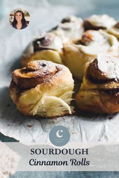 some cinnamon rolls are sitting on top of wax paper with the words sourdough cinnamon rolls