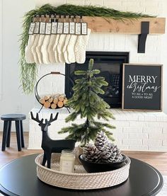 a christmas tree in a basket on top of a coffee table next to a fireplace