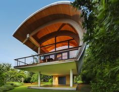 an unusual house in the middle of some trees