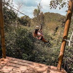 a woman on a zip line in the woods