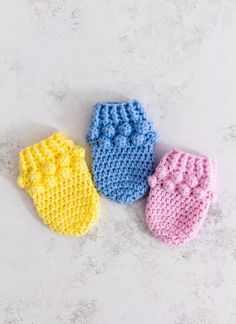 three crocheted baby mittens made and knitted with free pattern on top