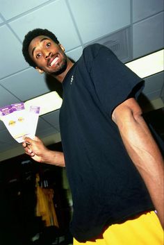 a man holding a white frisbee in his right hand and smiling at the camera