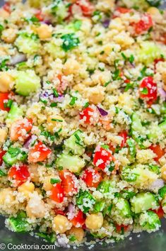 a bowl filled with vegetables and grains on top of a table