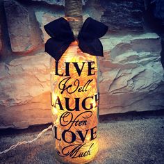 a lighted bottle that says live well, laugh love much with a bow on it