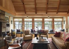 a living room with couches, chairs and a fire place in front of two windows