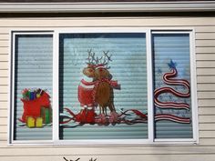 a window decorated with christmas decorations and reindeers