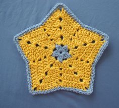 a crocheted yellow and blue star on a gray surface