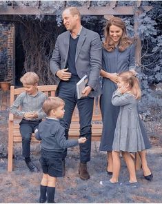 the royal family is standing in front of a wooden bench with two young children and one older man