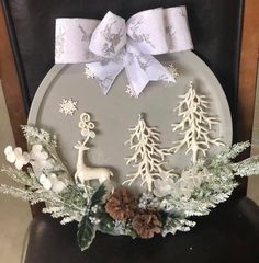 a christmas scene is displayed on the back of a chair with snowflakes and pine cones