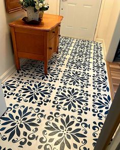 a white and blue floor with a flower pot on the end table in front of it