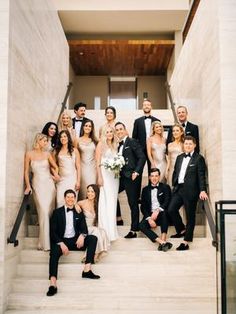 a group of people in formal wear posing on stairs